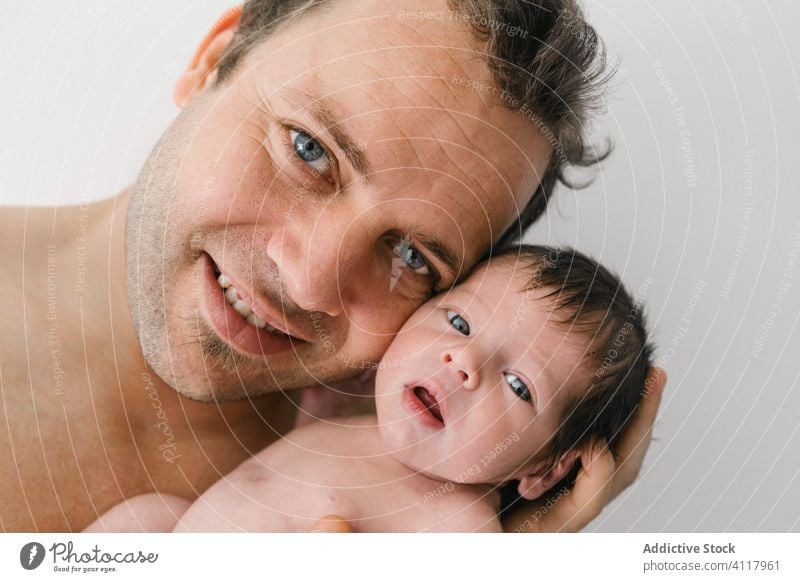 Happy father with little baby newborn happy man love parent embrace cuddle portrait cheerful male child hug smile kid dad together sweet infant childhood care