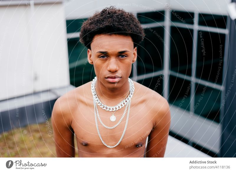 Shirtless ethnic man with chain necklaces trendy cool street style naked torso young confident modern black african american male urban fashion contemporary