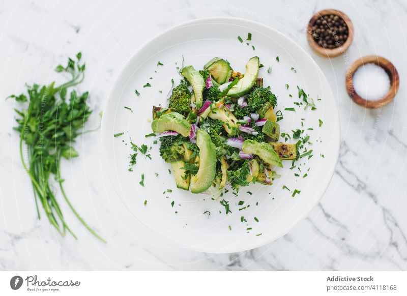 Fresh greens of parsley and broccoli in avocado salad plate zucchini vegetable serve fresh vegetarian cilantro kitchen round seasoning delicious portion