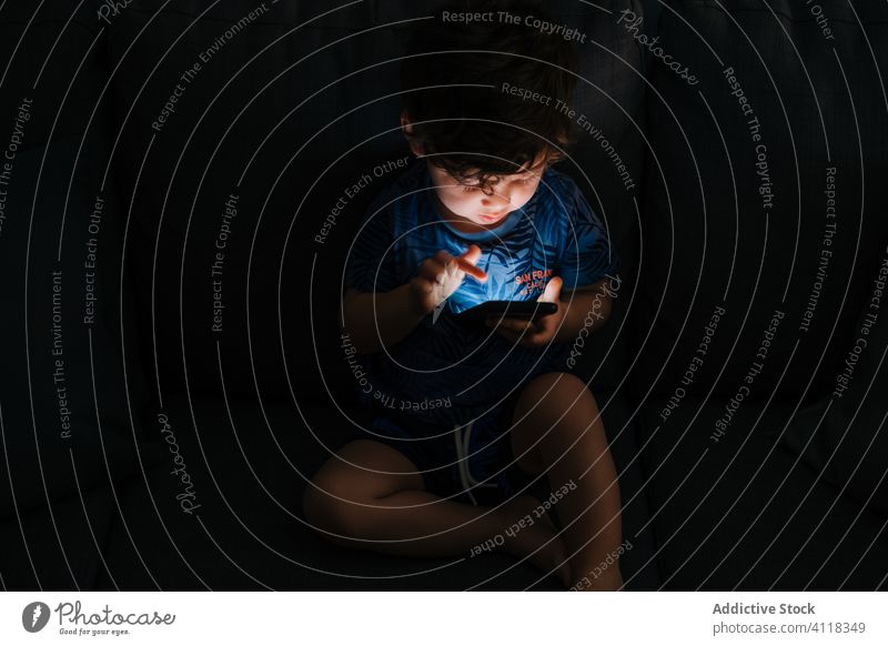 Curious little boy browsing smartphone at home child education application homework gadget communication connection technology room childhood kid sitting