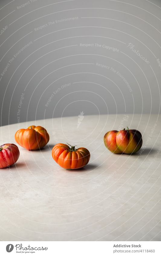 Ripening tomatoes on white table red fresh ripen natural raw food vegetable cook whole appetizing kitchen healthy meal vegetarian eat diet harvest cuisine