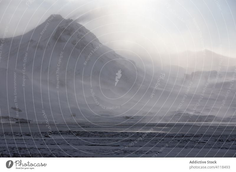 Snow covered volcano in foggy mountainous terrain severe wild winter snow blizzard haze cold arctic landscape range iceland rock nature mist travel rough slope