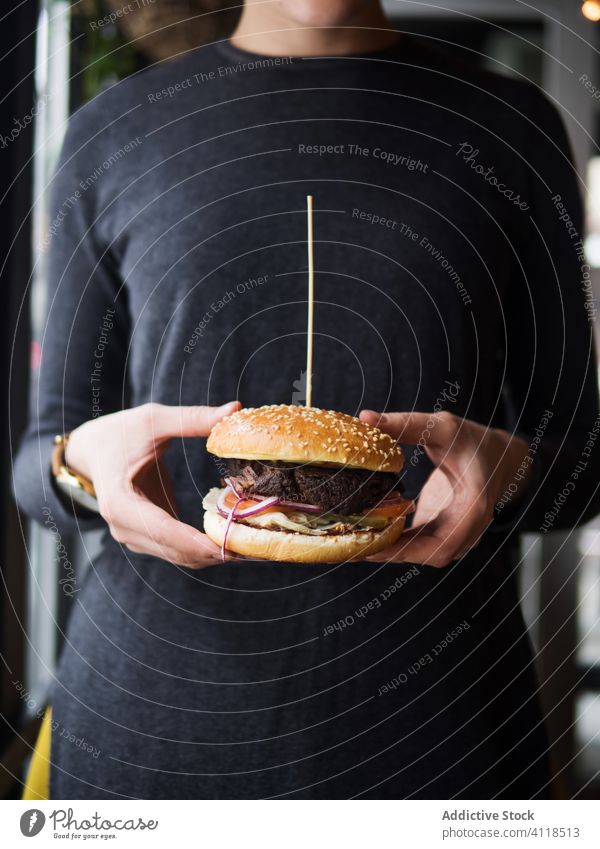 Person holding hamburger in hands fast food snack junk food meat beef lunch dinner unhealthy meal person cuisine bun dish classic sesame bread appetizing salad