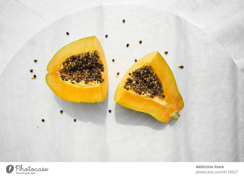 Halves of ripe papaya on table tropical half seed fresh food fruit dessert cut healthy meal shade gourmet summer sweet snack vegetarian vegan diet exotic