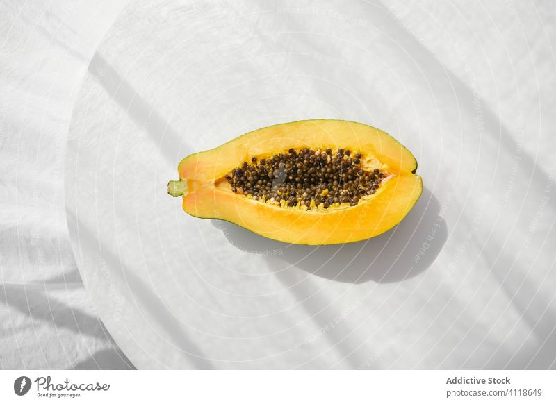 Halves of ripe papaya on table tropical half seed fresh food fruit dessert cut healthy meal shade gourmet summer sweet snack vegetarian vegan diet exotic