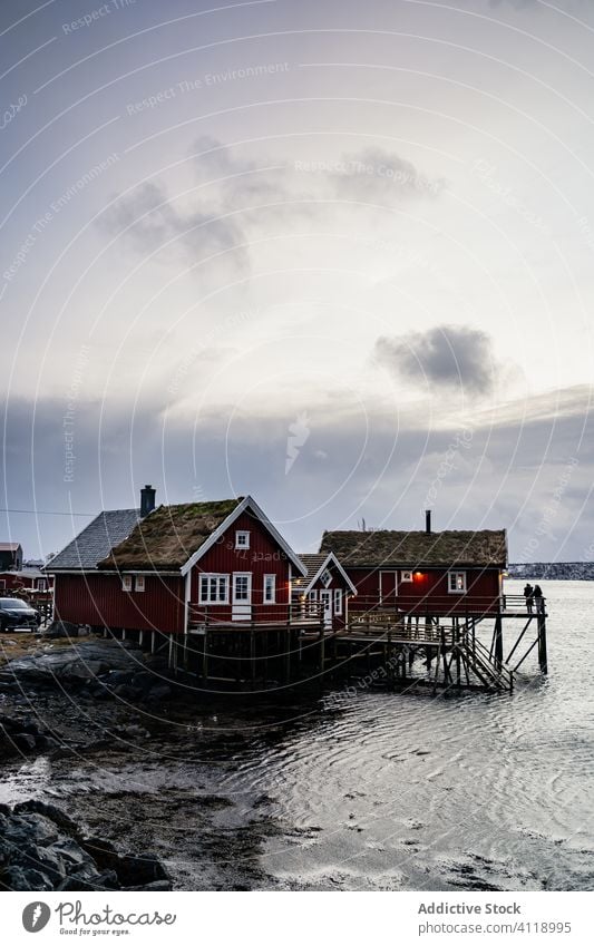 Small cottages on river shore under cloudy sky house beach water waterfront fjord scenic idyllic tranquil countryside norway coast settlement lofoten village