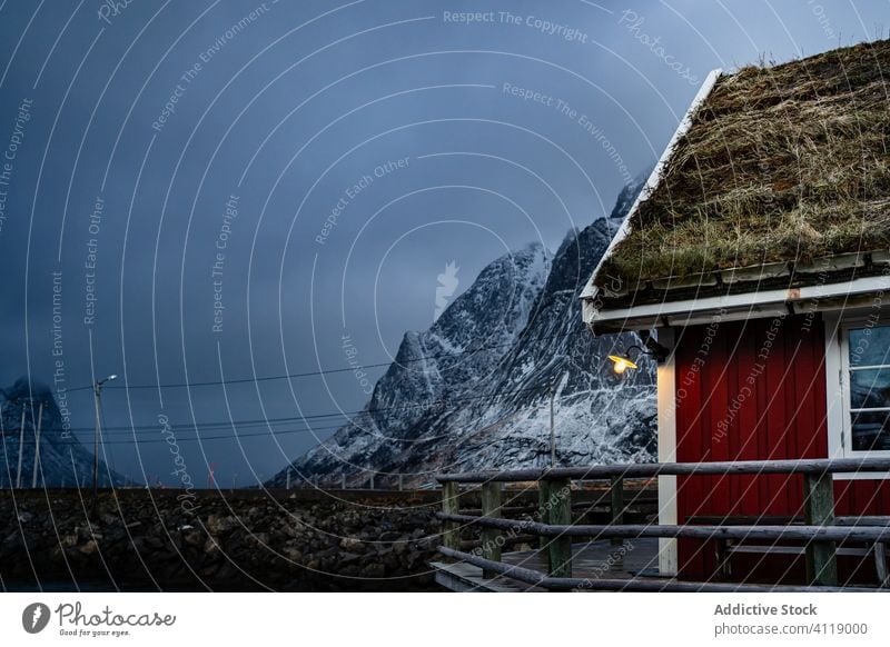 Small country house on lake in winter cottage pier shore foothill waterfront sky snow township countryside coast lofoten idyllic facade shoreline tranquil