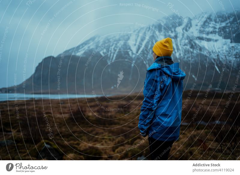 Lonely traveler admiring landscape in snowy highland in overcast weather woman mountain fresh admire vacation tourism wintertime trip peaceful breathtaking calm