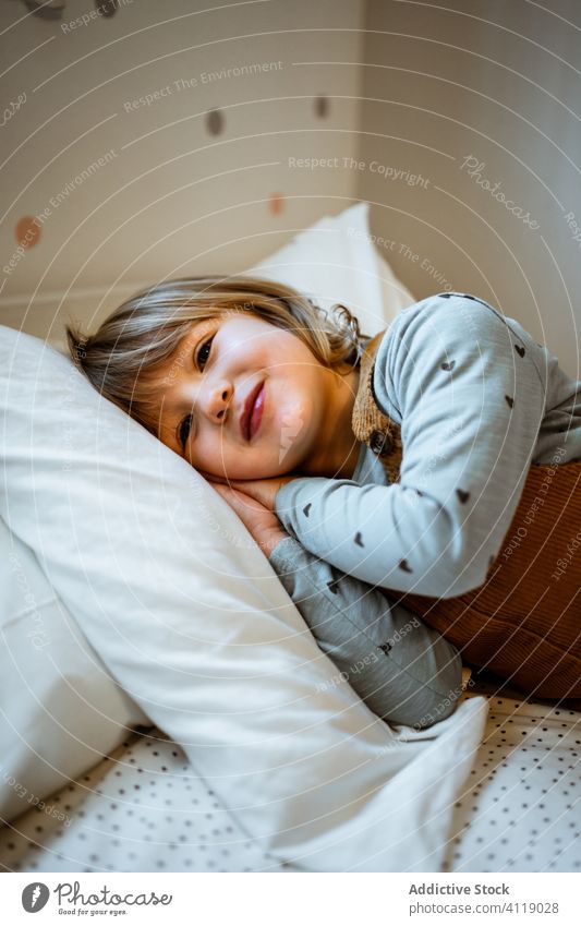 Cute girl looking at camera home cozy rest cute casual calm portrait little outfit adorable kid room childhood relax innocent domestic blond harmony tranquil