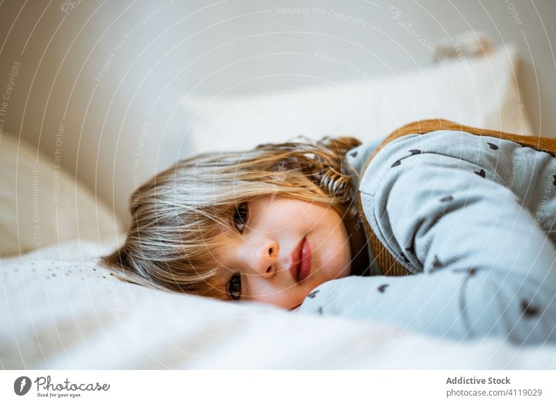 Cute girl looking at camera home cozy rest cute casual calm portrait little outfit adorable kid room childhood relax innocent domestic blond harmony tranquil