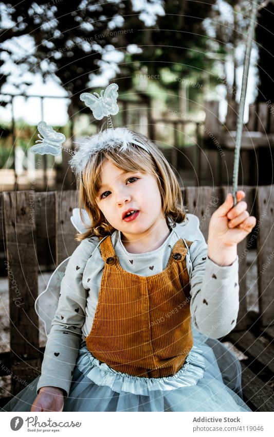 Little fairy sitting in yard girl costume bench shabby cute little play adorable child kid park childhood garden weathered masquerade relax seat rest magic