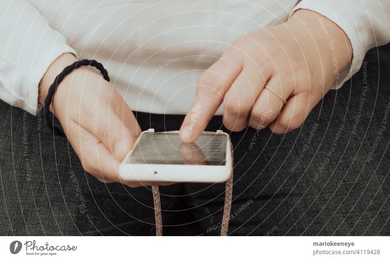 Close-up of a woman's hands consulting a smartphone detailed view technology holding close-up using addiction dependence mobile telephone cellphone