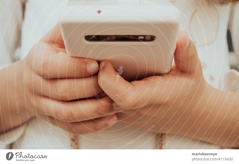 Close-up of a smartphone and the hands of a little girl detailed view technology holding close-up using addiction dependence mobile telephone cellphone