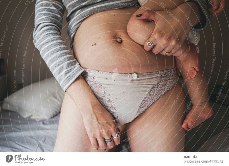 Real image of a woman and her baby at postpartum recovery childbirth motherhood real body positive people mom home quarantine belly belly button pregnancy