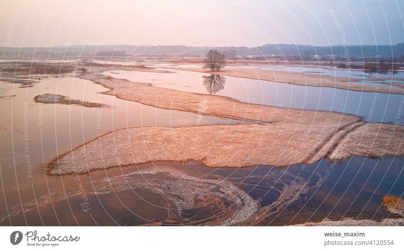 Sunrise spring melting river flood aerial panorama. Overflow water at springtime. Rural April landscape. overflow deluge inundation floodwaters spate alluvion