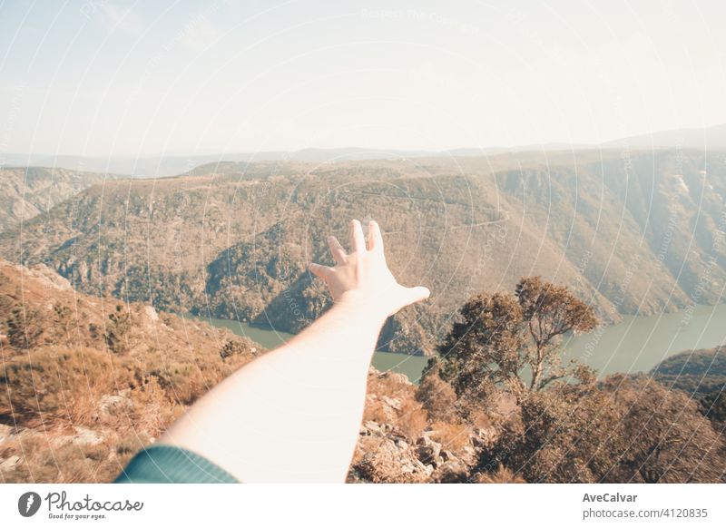 Close up of a hand in front of a super massive river in the middle of the forest during a spring day with copy space liberty concept person power one wilderness