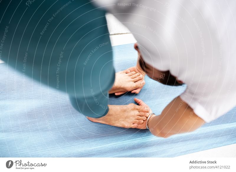 Man in Gorilla pose on mat man yoga exercise training gorilla pose bend barefoot modern stretch fitness shape male sportswear architecture contemporary zen