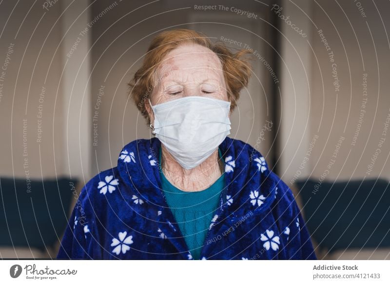 Aged woman in medical mask standing and looking at camera hospital infection disease virus protect room risk group clinic senior aged self isolation quarantine