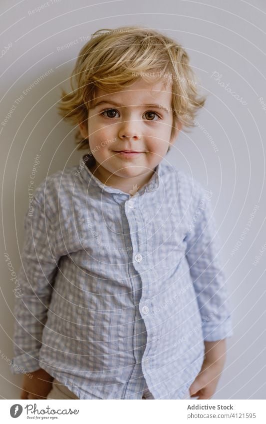 Delighted boy smiling and pointing at camera smile delight little kid adorable child content cheerful optimist cute childhood positive casual face expression