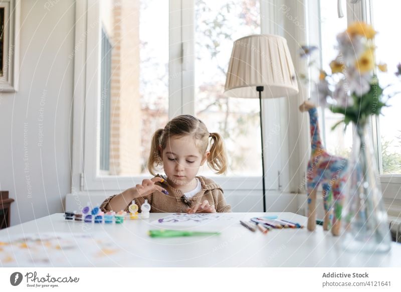 Little girl using gouache for drawing with fingers on paper at home child paint kindergarten creative kid cute education pencil learn elementary little adorable