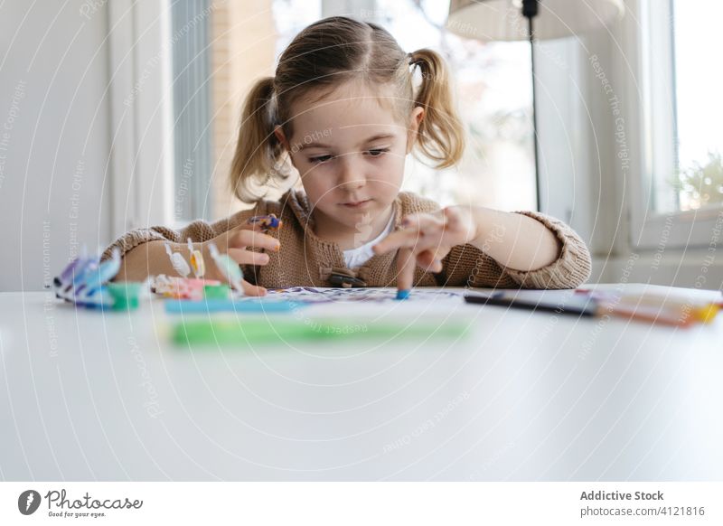 Little girl using gouache for drawing with fingers on paper at home child paint kindergarten creative kid cute education pencil learn elementary little adorable