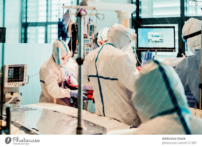 Doctors in protective uniform working in operating room in hospital doctor clinic viral patient care infection equipment treat specialist mask health care