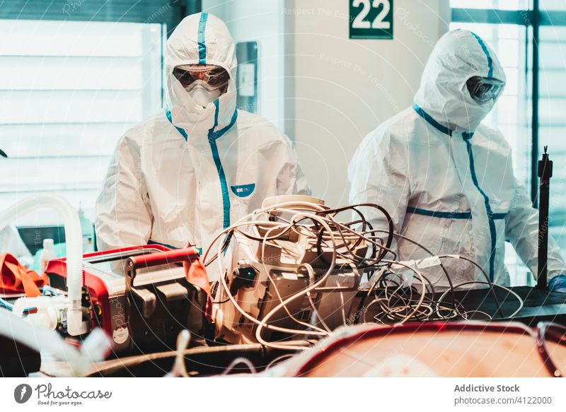 Doctors in protective uniform working in operating room in hospital doctor clinic viral patient care infection equipment treat specialist mask health care