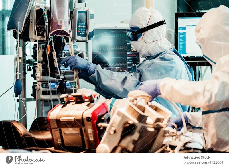 Interior of ambulance car with doctors in protective suit group uniform equipment patient service hospital clinic professional work vehicle health care mask