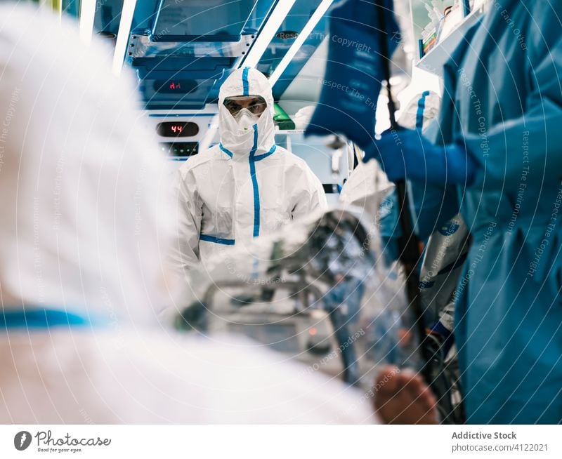 Interior of ambulance car with doctors in protective suit group uniform equipment patient service hospital clinic professional work vehicle health care mask