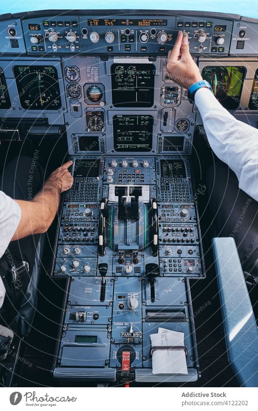 Pilots working in cockpit during flight pilot operate men airplane control dashboard equipment aviator male captain check modern aircraft transport instrument