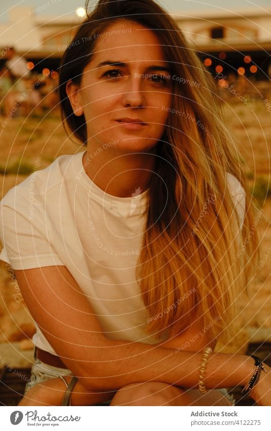 Young female tourist resting on seafront in evening woman stone sunset seashore dream inspiration observe ibiza spain coast relax vacation travel nature beach