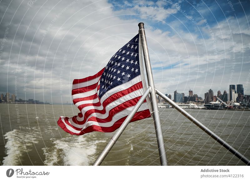 American flag on floating boat national usa vessel water city coast sky cloudy american united states new york nyc patriot wave building wind cityscape travel