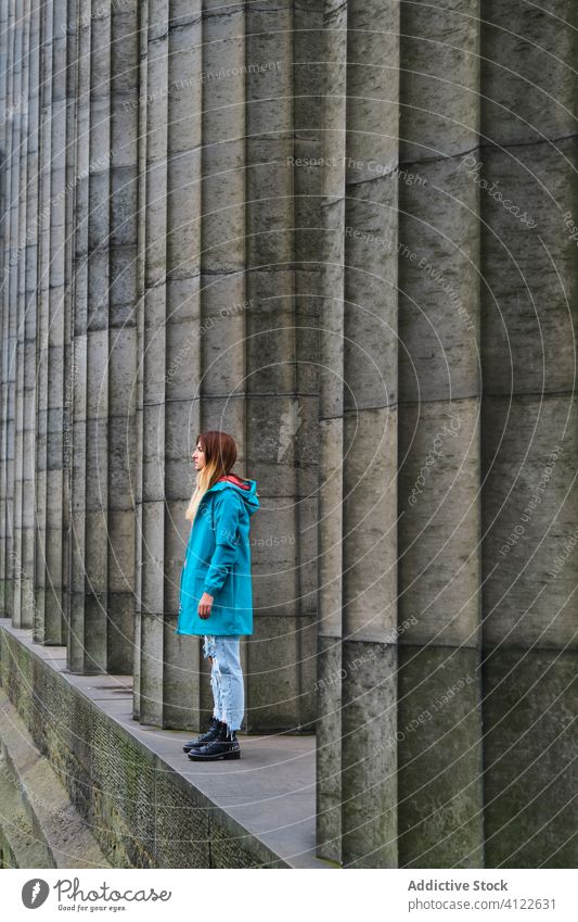 Woman standing on ancient concrete memorial monument woman travel show column tourism pillar female big blonde obelisk teenager alone color pedestal trip