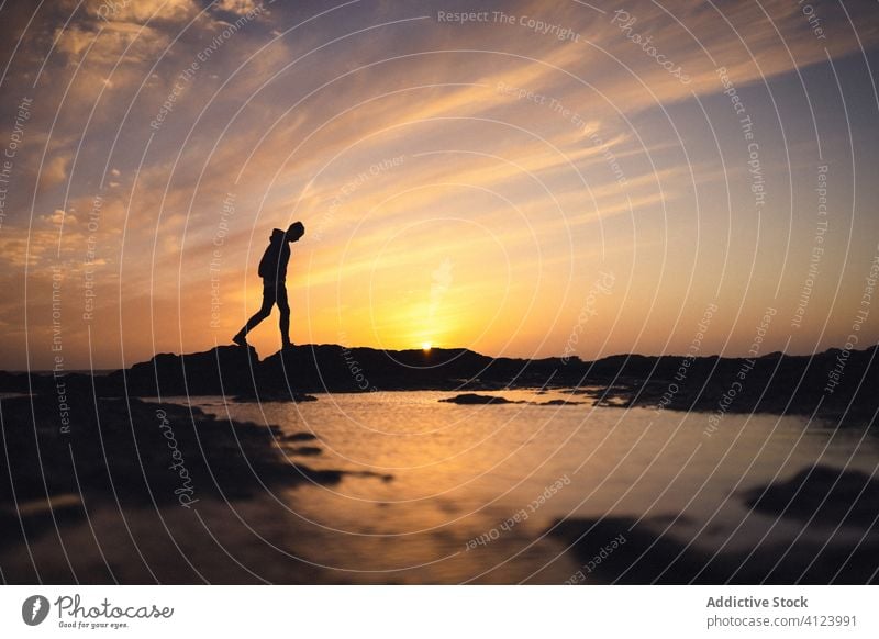 Unrecognizable person walking near water during sunset shore sky evening silhouette bright fuerteventura spain canary islands calm sundown twilight dusk