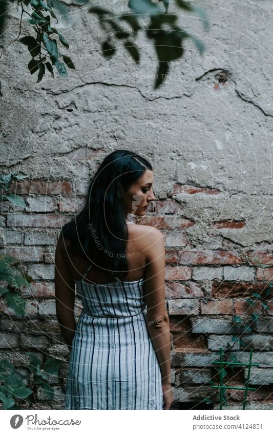 Young woman standing in a garden old pavement style dress rest female path plant relax serene tranquil peaceful harmony calm summer idyllic flora stripe elegant