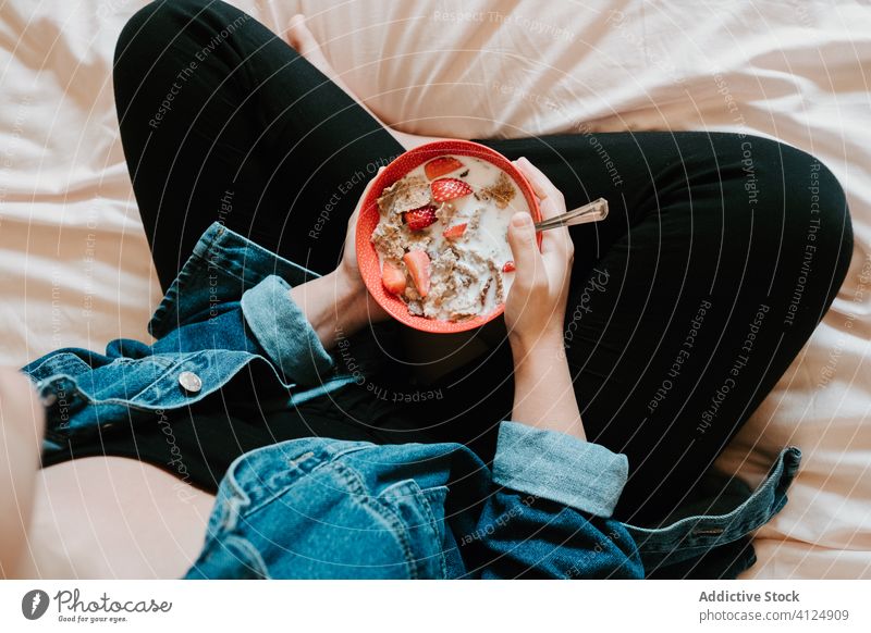 Woman eating dairy mix of strawberry and oatmeal at home woman milk hand bowl food diet healthy red female taste liquid breakfast cereal nutrition fresh piece