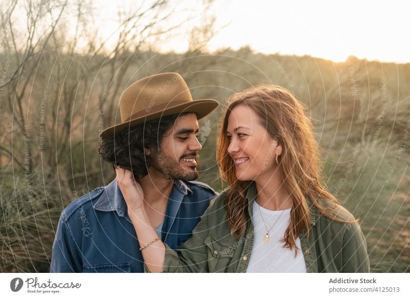 Happy couple hugging in countryside evening date love bush happy tender sunset man woman cheerful romantic lifestyle smile leafless nature relationship together