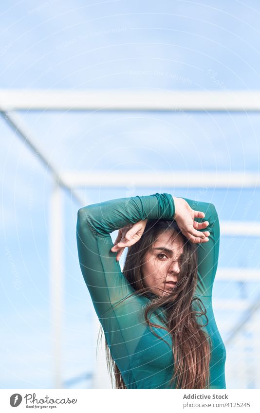 Confident woman looking at camera nature confident independent dance sensual posture sky serious contemporary modern young construction portrait geometry frame