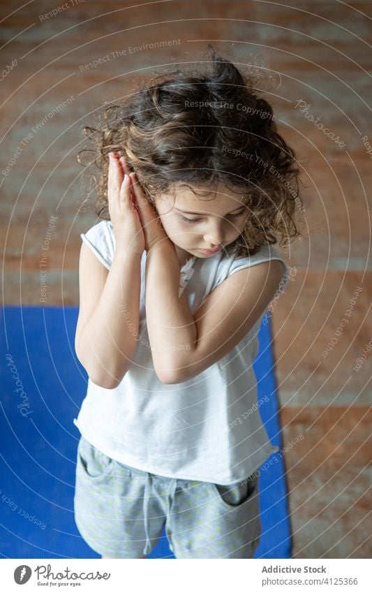 Little child doing namaste gesture practicing yoga kid practice home girl prayer pose calm tranquil mat little healthy energy female meditate concentrate zen