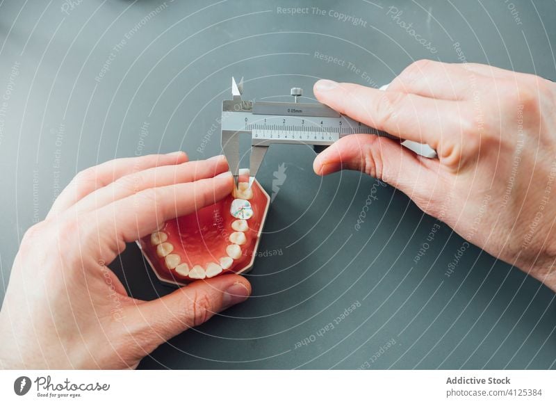 Dentistry student measuring tooth during class dentistry measure prosthesis tool caliper jaw medicine equipment study professional learn table instrument