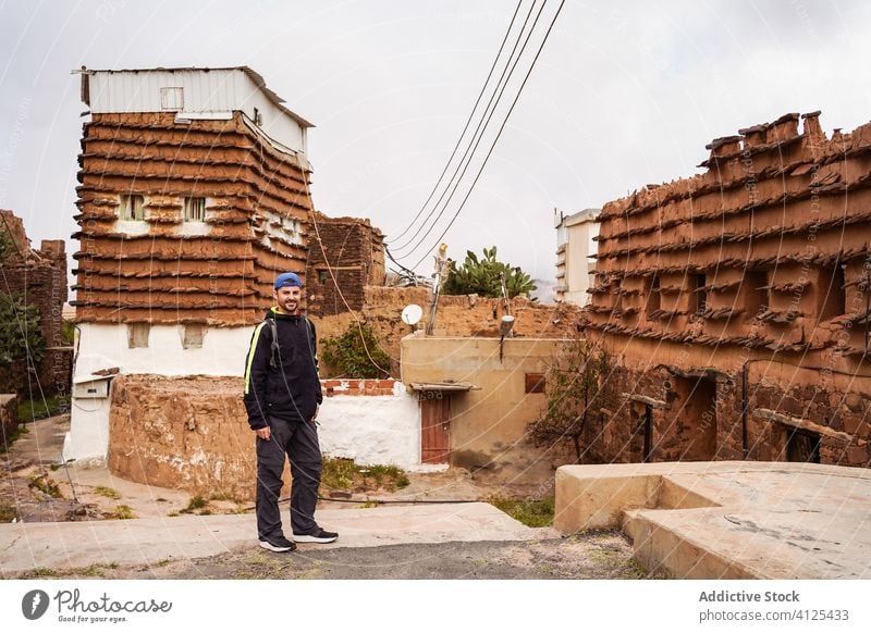 Man near shabby houses of town man district gray travel building male architecture trip exterior tourism vacation tourist holiday aged traveler old weathered