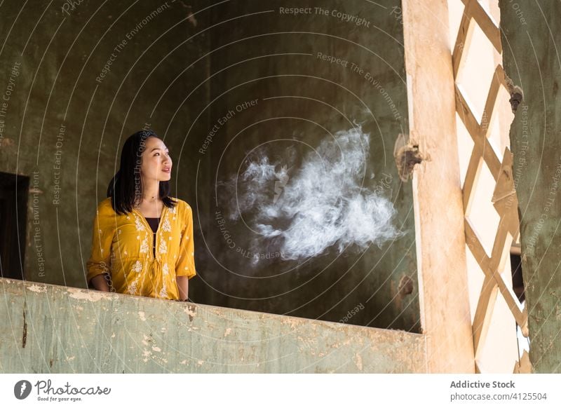 Young woman standing on balcony of old building architecture stone aged exterior design style street facade saudi arabia jeddah asia ethnic young weathered