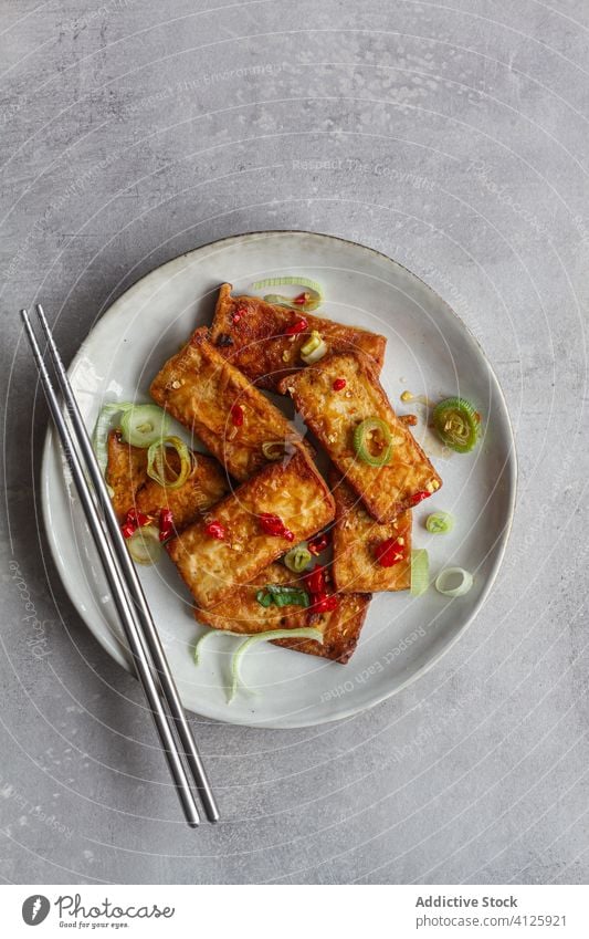 Tofu slices in soy sauce on table tofu vegetarian cook marinate chopsticks recipe garlic plate towel asian food fragrant steel delicious cuisine kitchen meal