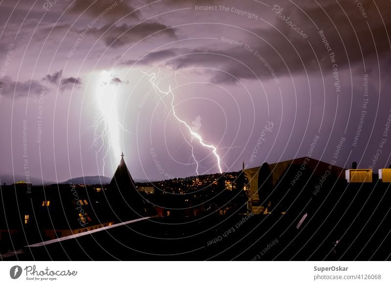 Lightning and thunder in the city of Oslo, Norway. Lightning almost strikes Frogner Church during a summer thunderstorm. The photo was taken from the roof.