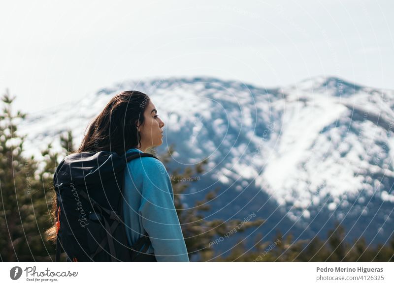 side view of a beauty female hiker in a snowy mountains nature hiking adventure travel landscape people woman lifestyle outdoor winter cold tourism sky