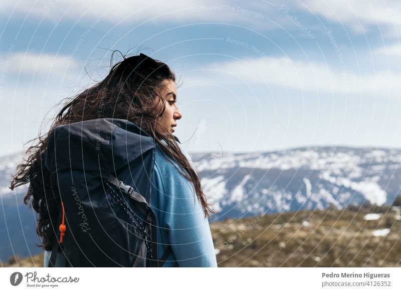 side view of a woman standing looking at mountain landscape. Close - up nature travel people portrait caucasian female adult person one lifestyle happiness