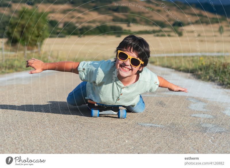 happy kid with skateboard and sunglasses on the road sport child travel childhood skater happiness skating activity lifestyle active city leisure urban smile