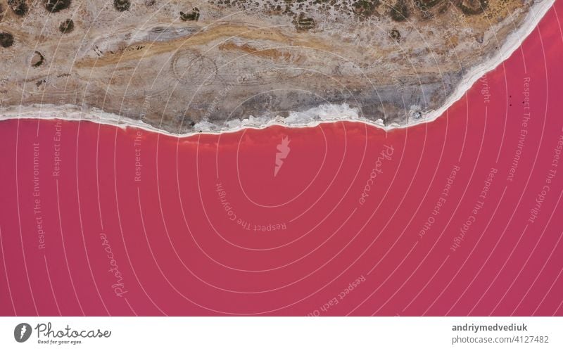 Aerial drone top down photo of a natural pink lake and coast Genichesk, Ukraine. Lake naturally turns pink due to salts and small crustacean Artemia in the water. This miracle is rare.