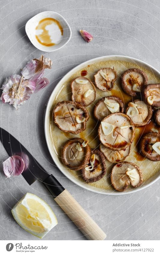 Fresh mushrooms with chopped garlic on ceramic tray food knife dish raw cooking meal fresh shiitake tasty uncooked cap homemade prepare recipe gastronomy