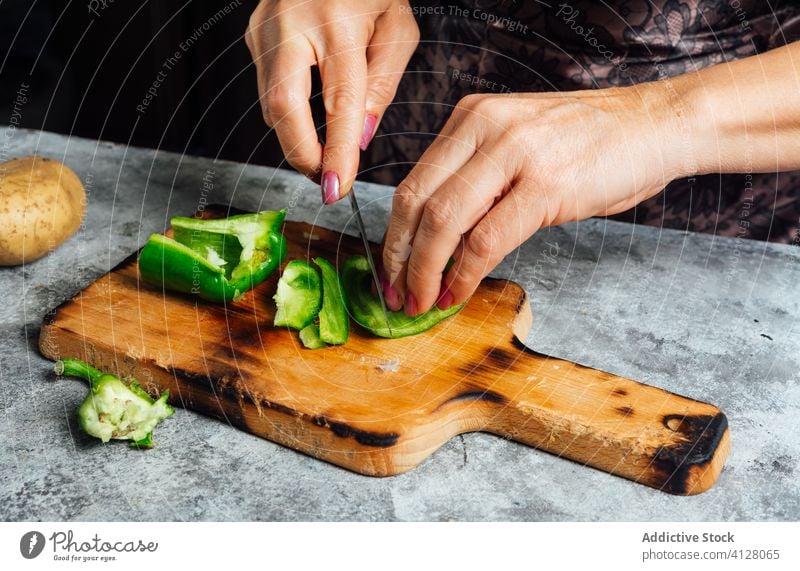 Crop female cook cutting pepper in kitchen cutting board woman chop chopping board housewife knife prepare fresh table food uncooked cuisine culinary dinner